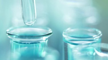 Bir laboratuarda, pipetli bir bilim adamı test tüplerindeki DNA ve molekülleri ayırmak için mavi bir sıvıyı analiz eder. Sıvıyla çalışan doktor..