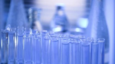 Bir laboratuarda, pipetli bir bilim adamı test tüplerindeki DNA ve molekülleri ayırmak için mavi bir sıvıyı analiz eder. Sıvıyla çalışan doktor..