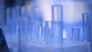 Bir laboratuarda, pipetli bir bilim adamı test tüplerindeki DNA ve molekülleri ayırmak için mavi bir sıvıyı analiz eder. Sıvıyla çalışan doktor..