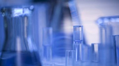 Bir laboratuarda, pipetli bir bilim adamı test tüplerindeki DNA ve molekülleri ayırmak için mavi bir sıvıyı analiz eder. Sıvıyla çalışan doktor..