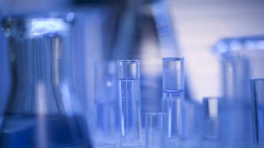 Bir laboratuarda, pipetli bir bilim adamı test tüplerindeki DNA ve molekülleri ayırmak için mavi bir sıvıyı analiz eder. Sıvıyla çalışan doktor..
