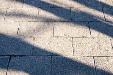 Taş yolunu güneş ışığı ve ağaç dalları gölgesi ile engellemek. Arka plan ve doku.