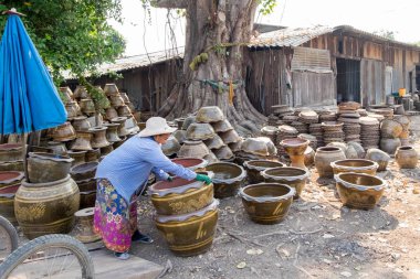 19 Aralık 2017 - Ratchaburi, Tayland: büyük saksı ahşap sepeti hareket yaşlı kadın işçi.