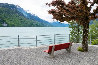 Boş kırmızı sandalye ve İsviçre Brienz kasabadan manzara.