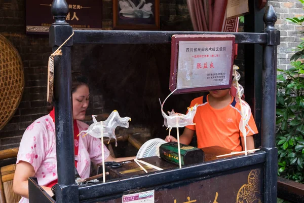 20 Temmuz 2017 - Chengdu, Çin: bir kadın tarafından yapılmış şeker şeker sanat arkasında bar Chengdu Jinli yaya sokakta. Bu nadiren nowsaday görmektir el yapımı bir çalışmadır.
