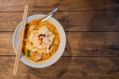 Tahta masada kıymalı domuz eti ve sahanda yumurta ile Tom Lezzetli Erişte 'nin üst görüntüsü.