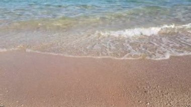 Kristal berraklığında su üzerinde yumuşak dalgalar ile altın kum plaj