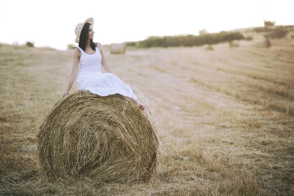 Sorrindo menina sentada na palha — Fotografia de Stock