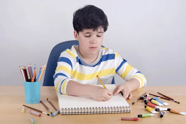 Мальчик рисует на деревянном столе — стоковое фото