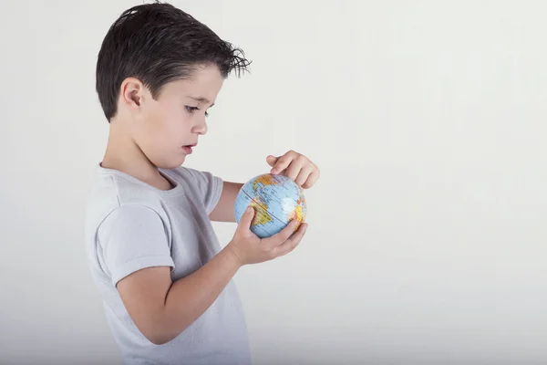 男孩看着玩具地球仪。在手中的孩子举行地球 — 图库照片