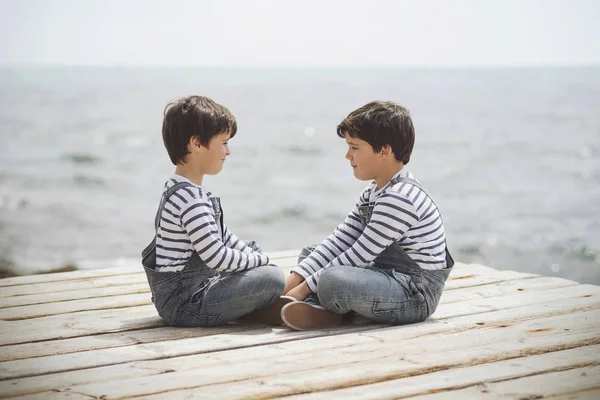 Bröderna sitter på waterfront — Stockfoto