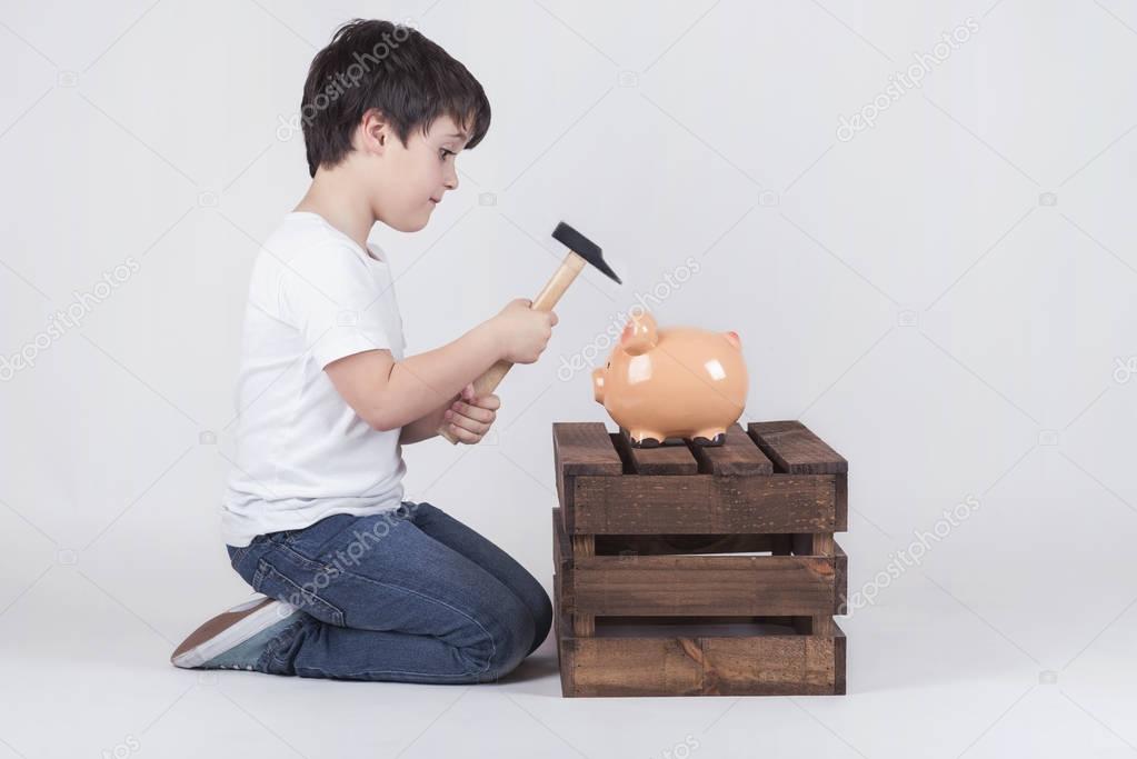 Little boy, His breaking piggy bank