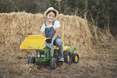 Oyuncak traktör çayır üzerinde ile oynayan çocuk