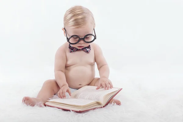 Liten glad bebis en bok med glasögon och slips — Stockfoto