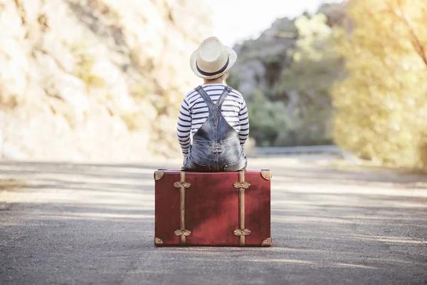 Jongen met koffer op de weg — Stockfoto