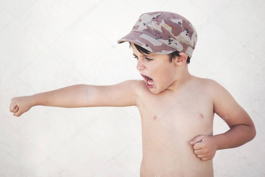 Aggressive child. Boy with cap making an aggressive gesture