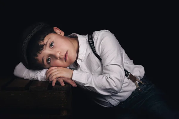 Niño pensativo sobre fondo negro — Foto de Stock