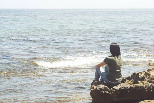 Pensive woman looking at the sea