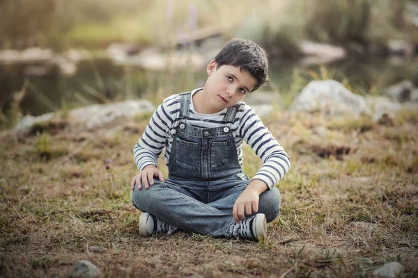Szomorú fiú ülő-ban mező — Stock Fotó