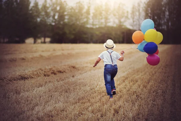 Pojke Som Kör Genom Fältet Med Ballonger — Stockfoto