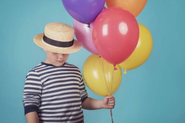 Balonlu mavi adam üzerinde düşünceli çocuk