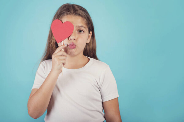 улыбающаяся девушка с закрывающим глаза сердцем
