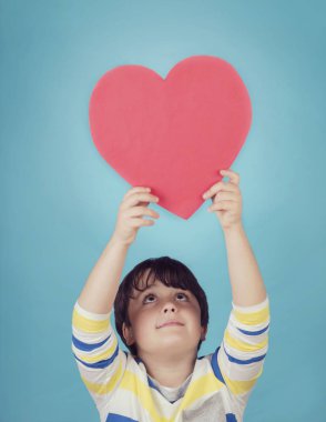 mavi arka plan üzerinde bir kalp ile boy gülümseyerek