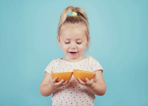 Улыбающийся Ребенок Апельсином Синем Фоне — стоковое фото