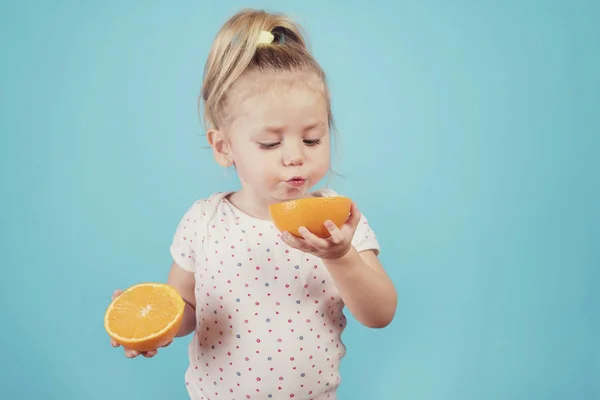 Bebê Comer Uma Laranja Fundo Azul — Fotografia de Stock