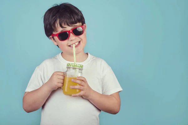 Niño Feliz Bebiendo Jugo Naranja Sobre Fondo Azul — Foto de Stock