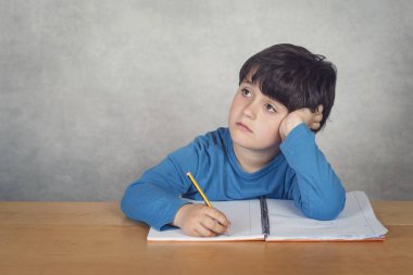 bir tabloda bir kitapla üzgün ve düşünceli çocuk