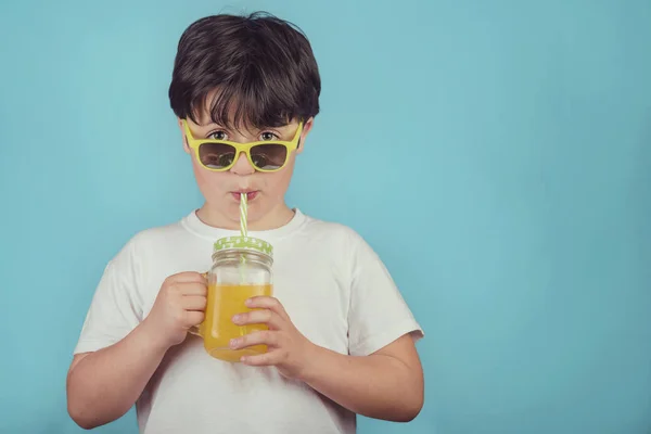 Niño Feliz Bebiendo Jugo Naranja Sobre Fondo Azul — Foto de Stock