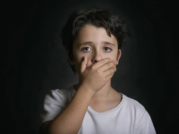 Ledsen pojke täcker sin mun med handen — Stockfoto