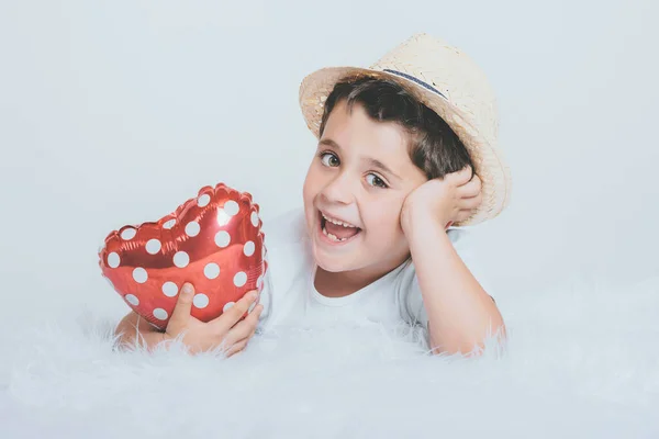 Niño sonriente con un globo en forma de corazón —  Fotos de Stock