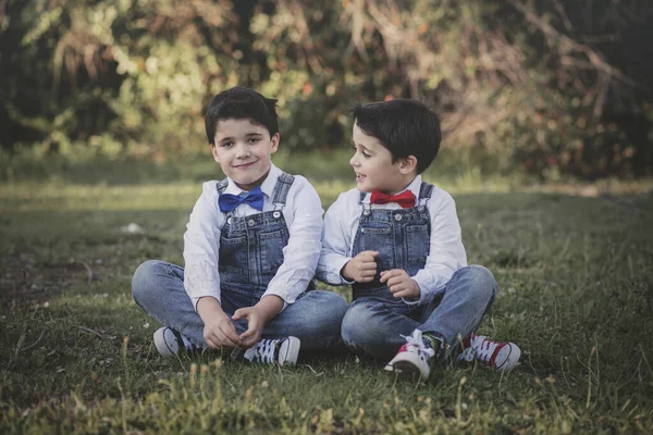 Bratři sedící na trávě — Stock fotografie