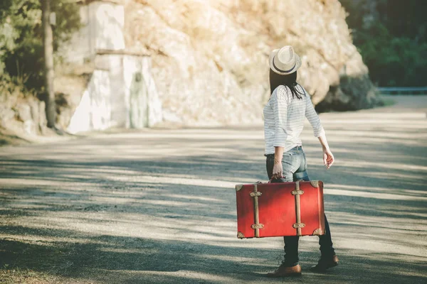 Dışarıda bavullu genç bir kadın var.