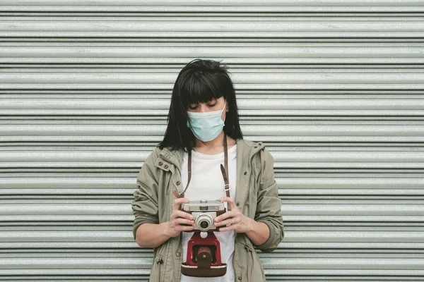 woman wearing medical mask take photos with its camera outdoor