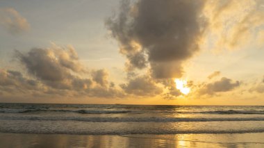 Sahilde gün batımı ve bulutlu