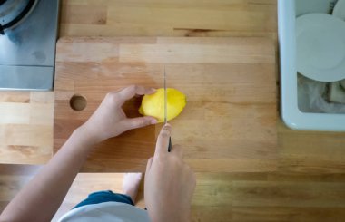 Mutfakta bıçaklı ve bir kaşık limonlu bir kadın.