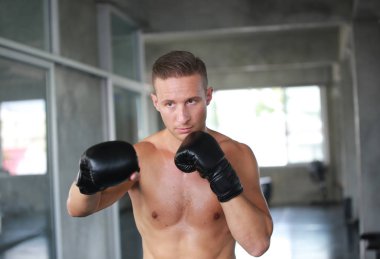 Boksör dövüş konsepti, spor salonunda İspanyol yumruk torbası genç adam boks, spor salonunda kum torbası.