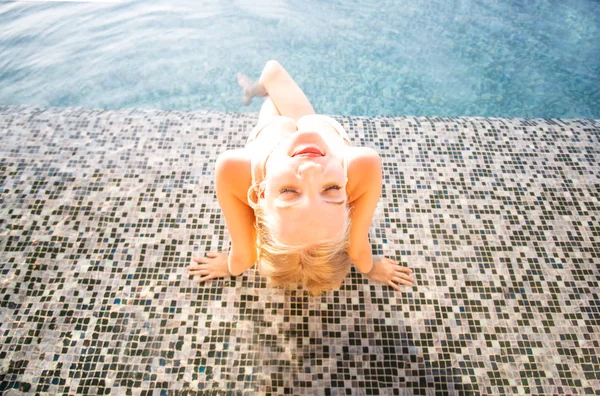 Young woman white bikini enjoying a sun, Slim young girl model in white bikini  by the pool.