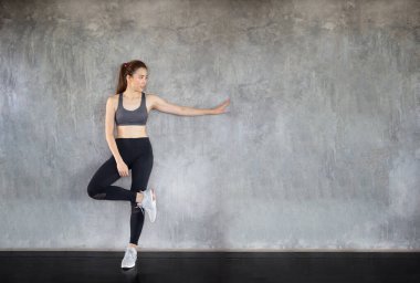 Spor salonunda spor yapan kadın spor yapıyor. Dambıl ve protein şişesiyle spor yaptıktan sonra elma meyvesi tutuyor. Sağlıklı vücut geliştirme, spor kasları geliştiriyor..