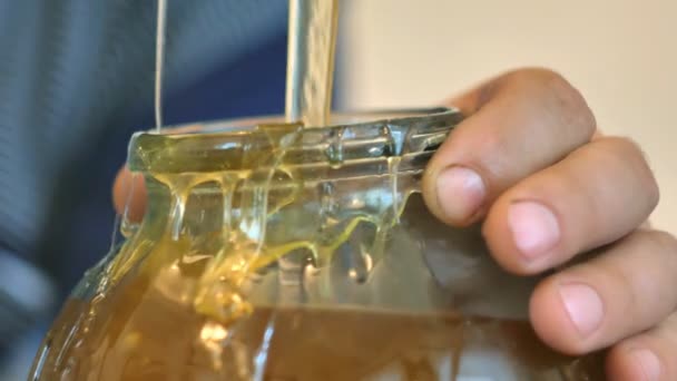 养蜂人蜂蜜倒进一个瓶子里，特写. — 图库视频影像