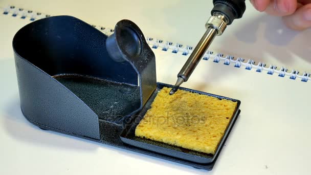 Limpiando la punta caliente de su soldador en una esponja húmeda . — Vídeo de stock