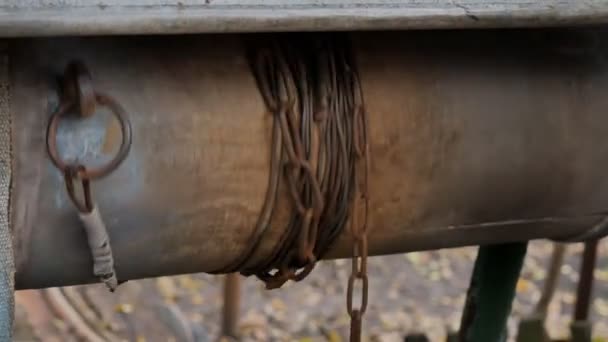 Člověk spadne řetěz s lopatou do rustikální dobře čerpat vodu. Špinavá voda. — Stock video