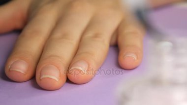 Closeup manikürcü jel tırnak cilası temelini fırsatlar. Manikür yapıyor.