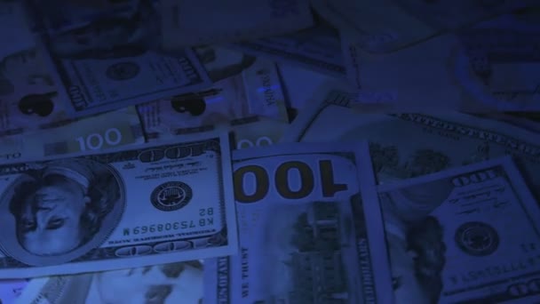 Geld auf den Tisch. Stückelungen. Dollar und Griwna. UV-Licht — Stockvideo