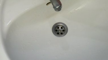 Lavaboda kirli paslı altın kahverengi dışarı başlar musluk su çalışır.