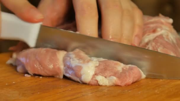 Kvinna skär kött med kniv i små bitar på skärbräda. — Stockvideo