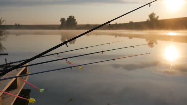 Angelrute auf dem Sonnenuntergang Fluss. Angelrute am Morgenhimmel. Nebel über dem Teich. — Stockvideo